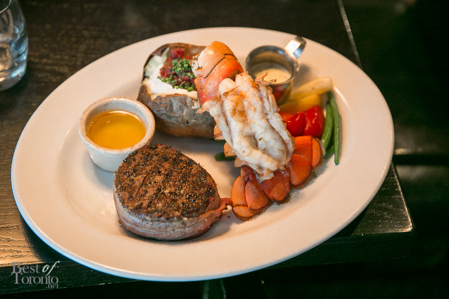 Some surf and turf including a filet mignon (rare), lobster tail with melted butter and a loaded baked potato with steamed vegetables