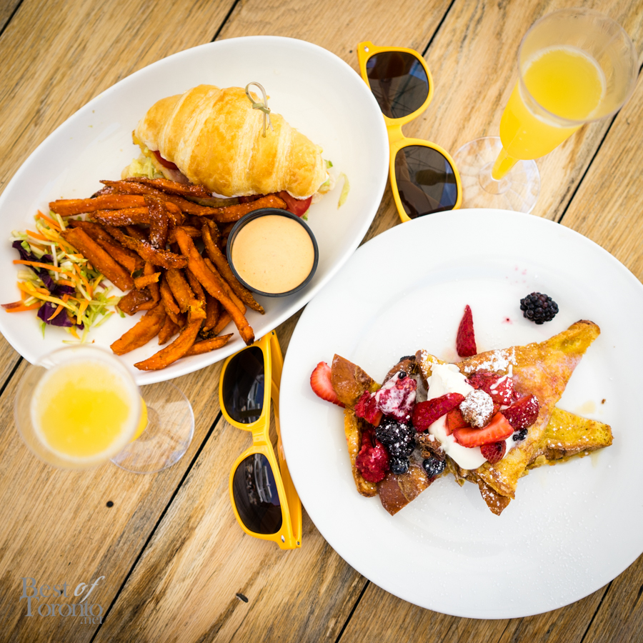 Left:  Peameal bacon and fried egg sandwich with O&B artisan butter croissant, lettuce, tomato, avocado mayo, sweet potato fries Right:  Cinnamon brioche french toast with seasonal fruit, chantilly, candied pecans, local syrup