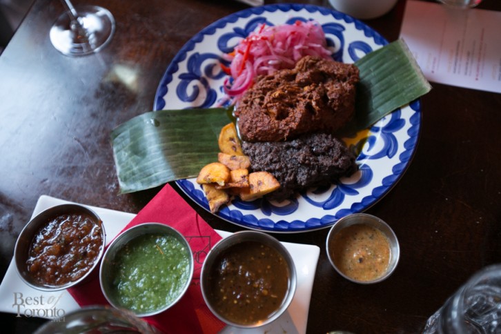 "Cochinita Pibil" with Southern style pork butt in ahciote and orange juice marinade, roasted in banana leaves, pulled and served with fried plantains, pickled red onions and salsa Pancho (habaneros, tomatillo, serrano salsa)