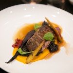 Roasted dry aged duck breast with coriander, carrot, mustard, greens, quinoa, and Saskatoon berries