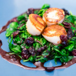 Pan seared scallops with baby spinach and spiced pomegranate