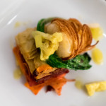 Potato wrapped cod, root vegetable and salt meat pave, mustard pickle vinaigrette
